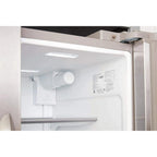 Close-up of a refrigerator interior with light on, showing shelves and a control panel.