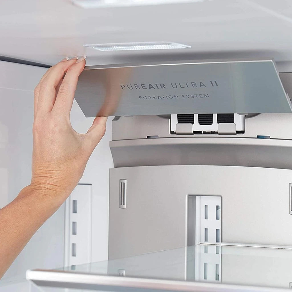 Hand reaching towards a PureAir Ultra II filtration system inside a refrigerator.