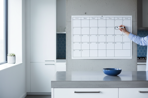 Person marking calendar in kitchen